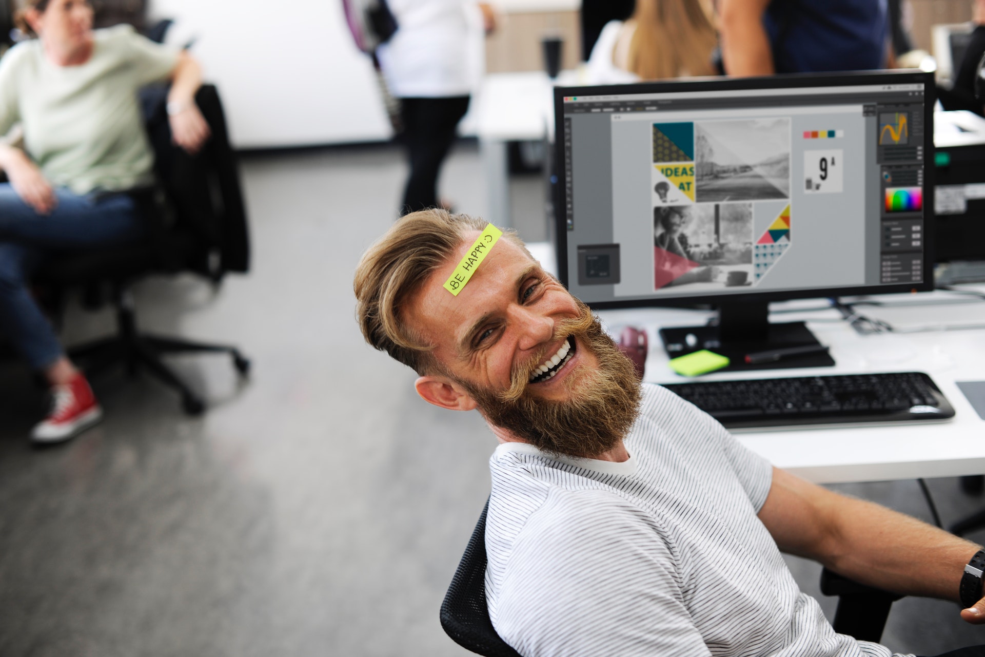 Man in office smiling with post-it on his head